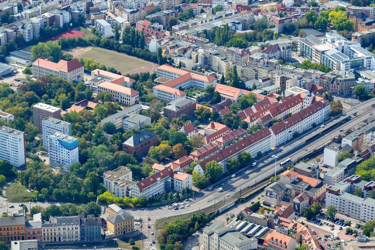 Luftaufnahme der Franckeschen Stiftungen in Halle mit langen Häuserzeilen mit roten Dächern, Grünflächen und einer Straße