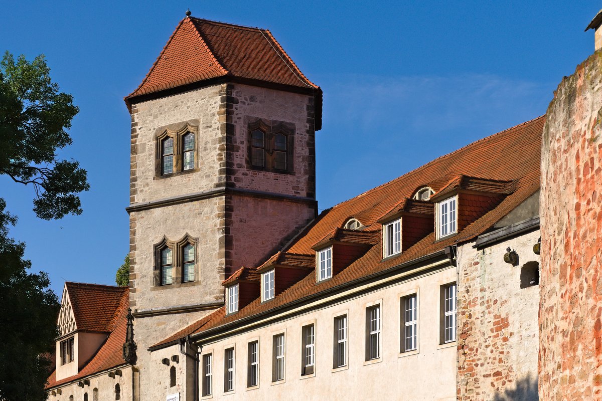 Der Turm der Moritzburg in Halle mit rotem Walmdach und Dachgauben, daneben ein lang gestreckter Flügel mit weißer Fassade